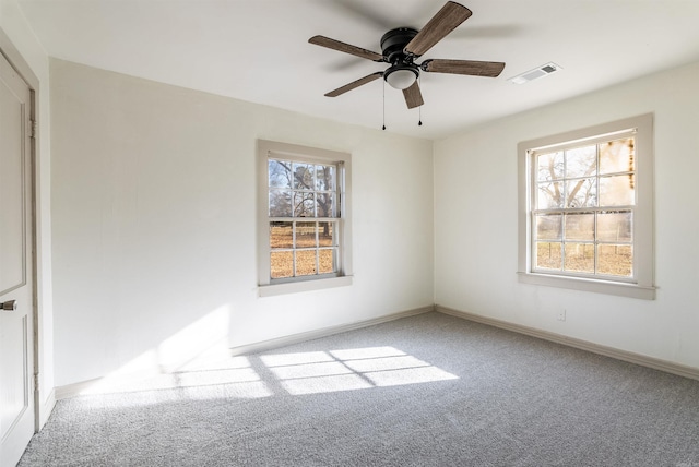 carpeted empty room featuring plenty of natural light and ceiling fan