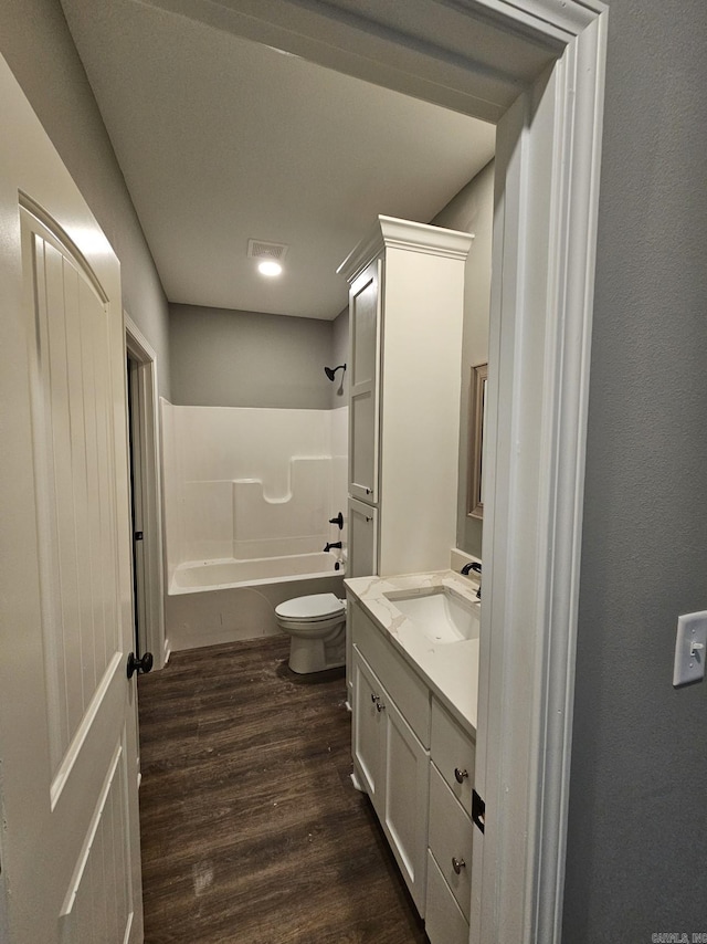 full bathroom with hardwood / wood-style flooring, vanity, toilet, and shower / tub combination