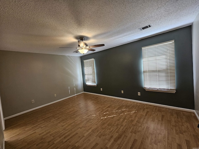 unfurnished room with ceiling fan, dark hardwood / wood-style flooring, and a textured ceiling