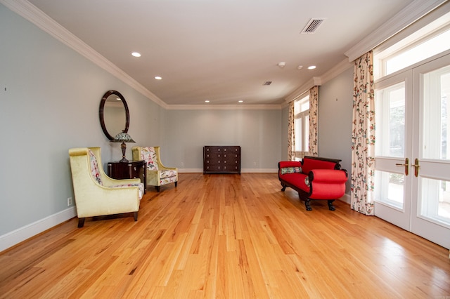 sitting room with crown molding, french doors, and light hardwood / wood-style flooring