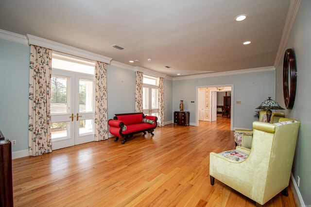 sitting room featuring french doors, light hardwood / wood-style flooring, and ornamental molding