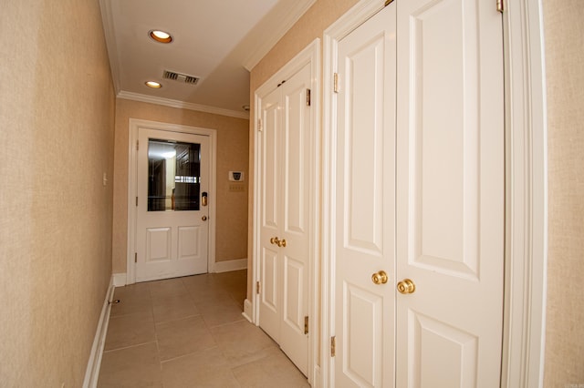 hallway with crown molding and light tile patterned flooring