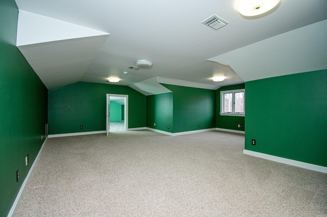 additional living space with carpet floors and vaulted ceiling