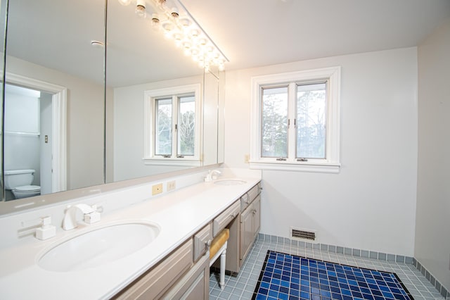 bathroom with tile patterned flooring, vanity, and toilet