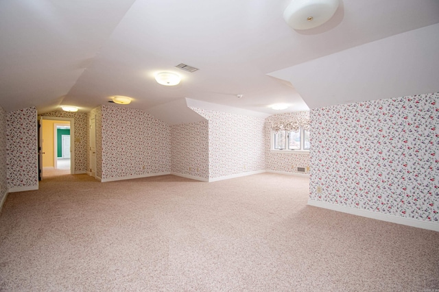 additional living space with carpet floors and vaulted ceiling