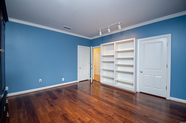 unfurnished bedroom with rail lighting, crown molding, and dark wood-type flooring