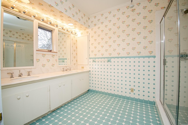 bathroom with crown molding, vanity, and a shower with shower door