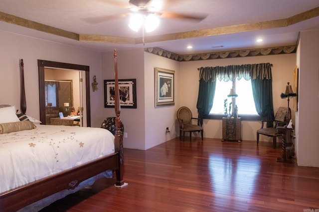 bedroom with a raised ceiling, ceiling fan, and dark hardwood / wood-style flooring