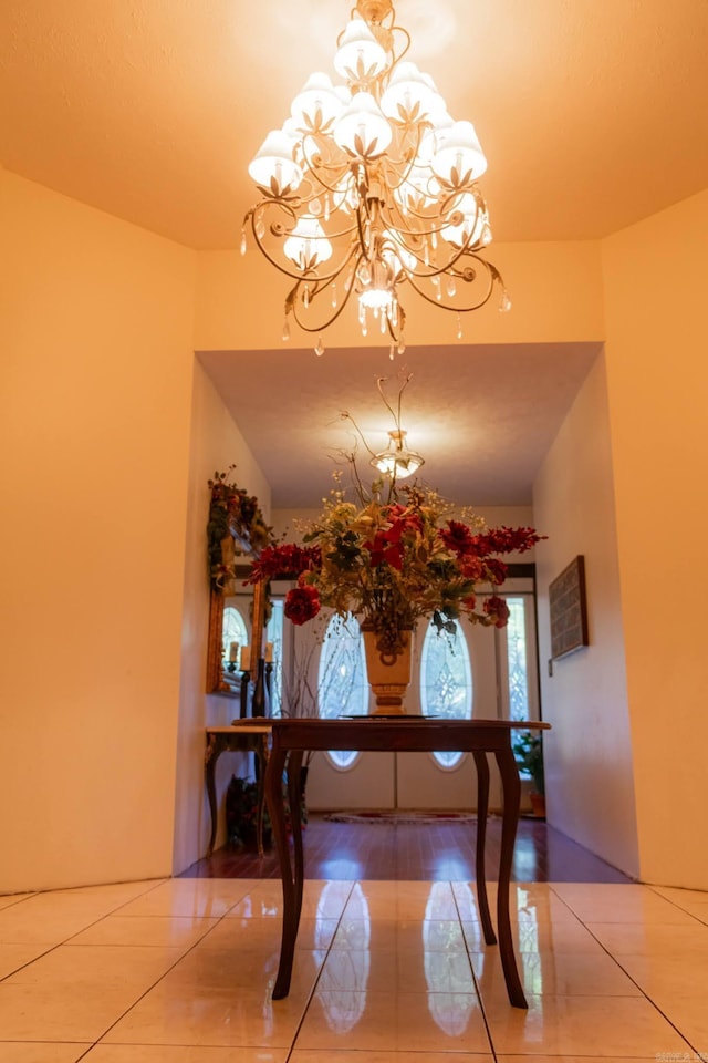 dining area with tile patterned flooring and an inviting chandelier