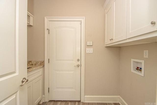 laundry room featuring light hardwood / wood-style floors, cabinets, and hookup for a washing machine