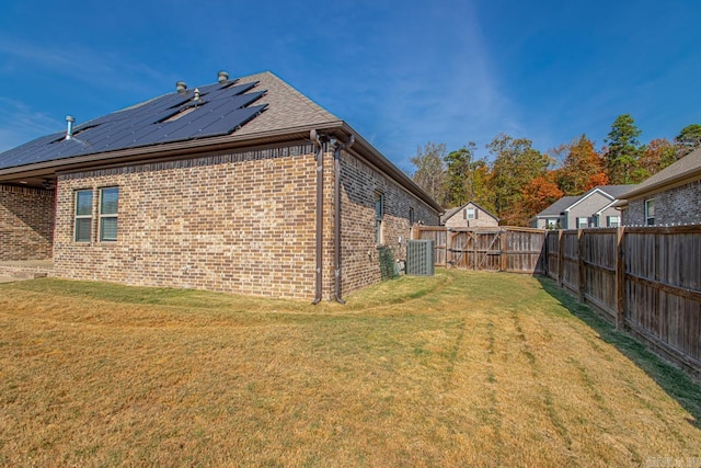 view of side of home featuring solar panels and a yard