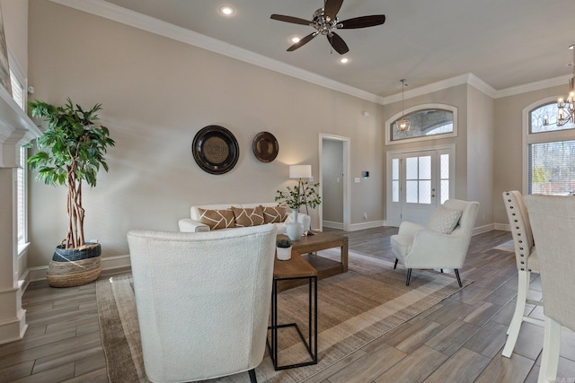 living room featuring crown molding and ceiling fan with notable chandelier