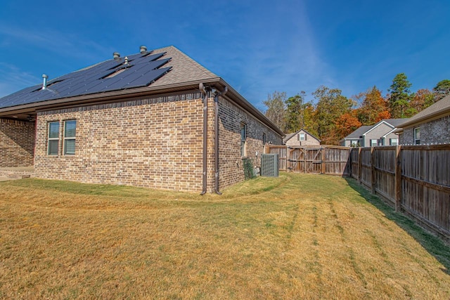 view of side of property featuring a lawn and solar panels