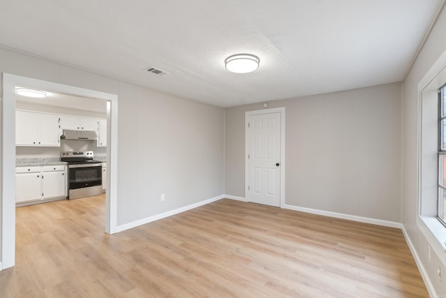 empty room featuring light wood-type flooring and a textured ceiling