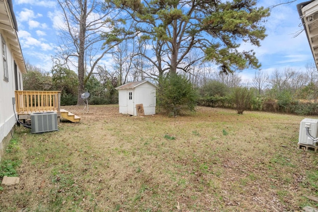 view of yard featuring central AC unit and a storage shed