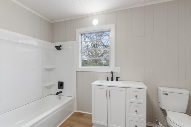 full bathroom with vanity,  shower combination, crown molding, hardwood / wood-style flooring, and toilet