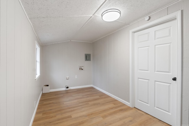 washroom featuring hookup for a washing machine, wooden walls, electric dryer hookup, crown molding, and light hardwood / wood-style floors