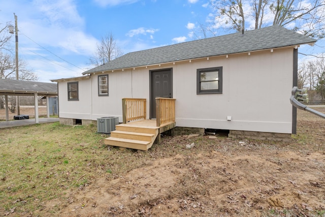 rear view of house featuring central AC unit and a carport