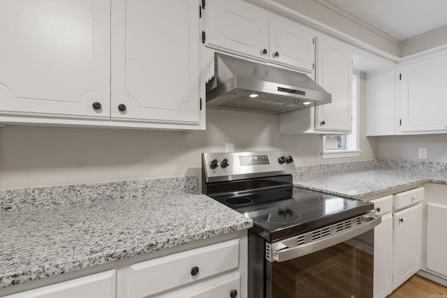 kitchen featuring stainless steel range with electric stovetop, white cabinets, light stone countertops, and light hardwood / wood-style flooring