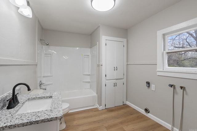 full bathroom featuring hardwood / wood-style floors, vanity, toilet, and shower / tub combination