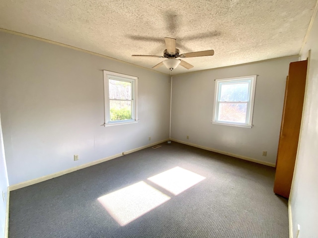 carpeted empty room featuring ceiling fan and a textured ceiling