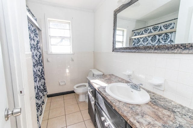 bathroom with tile patterned floors, toilet, vanity, tile walls, and ornamental molding