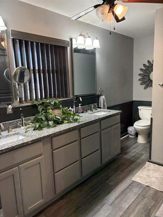 bathroom featuring vanity, hardwood / wood-style flooring, toilet, and ceiling fan