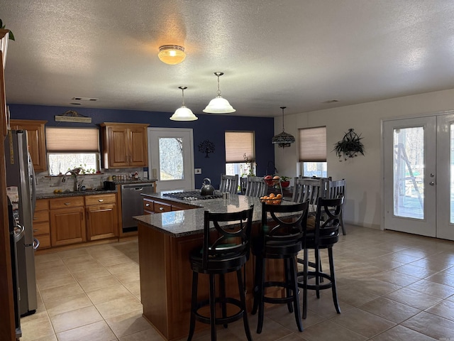 kitchen featuring a breakfast bar area, a center island, dark stone counters, and appliances with stainless steel finishes