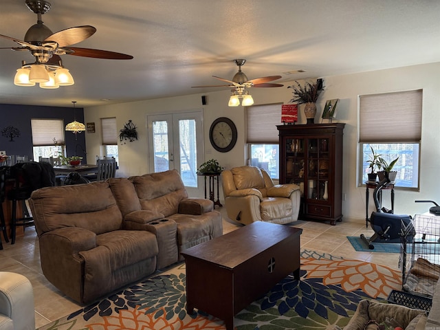 tiled living room with ceiling fan, french doors, and a textured ceiling