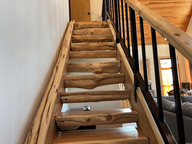 staircase featuring hardwood / wood-style flooring and wooden ceiling