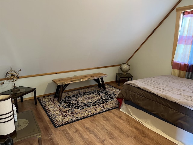 bedroom with hardwood / wood-style floors and vaulted ceiling