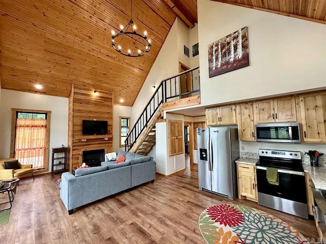 kitchen with light brown cabinets, high vaulted ceiling, stainless steel appliances, and a notable chandelier