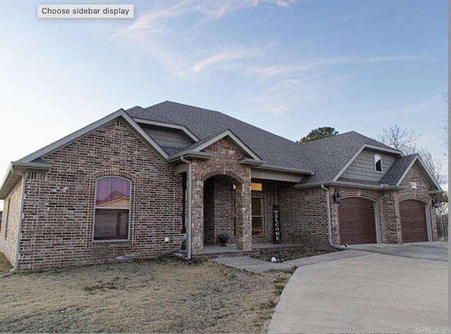 view of front facade featuring a garage, driveway, brick siding, and roof with shingles