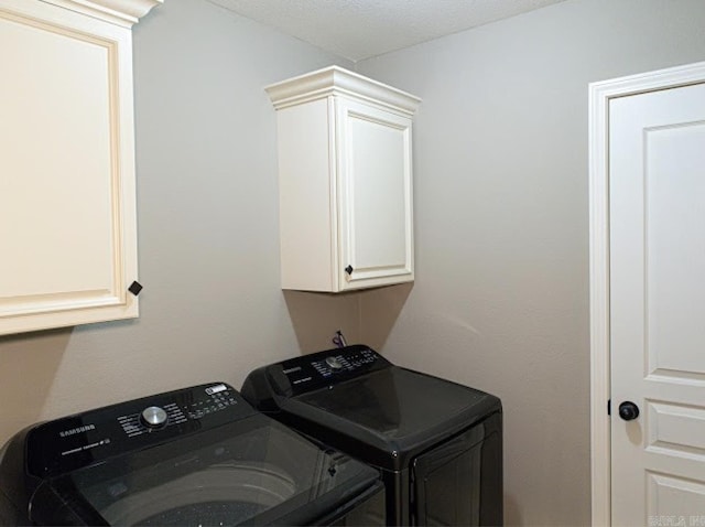 laundry room with separate washer and dryer and cabinets