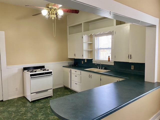 kitchen featuring white cabinets, white range oven, ceiling fan, and sink