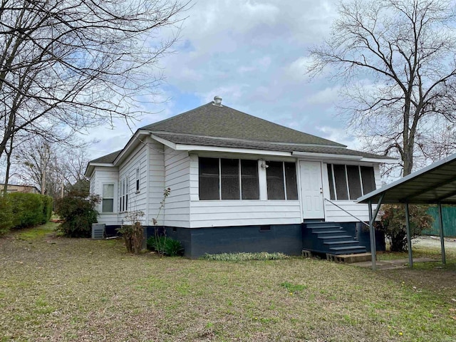 rear view of property featuring a lawn, central AC, and a sunroom