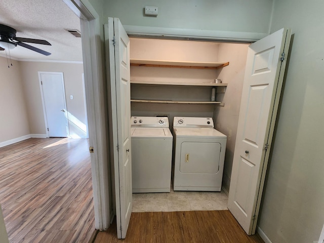 washroom featuring washer and clothes dryer, ceiling fan, a textured ceiling, and light hardwood / wood-style flooring