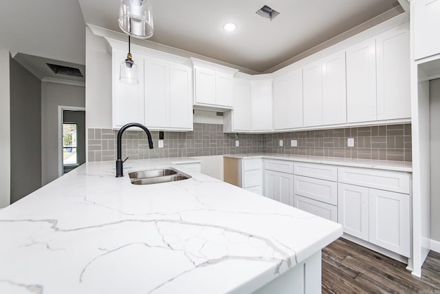 kitchen with white cabinetry, sink, tasteful backsplash, dark hardwood / wood-style floors, and decorative light fixtures