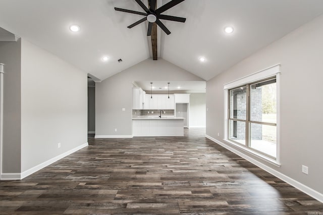 unfurnished living room with dark hardwood / wood-style floors, lofted ceiling with beams, and ceiling fan