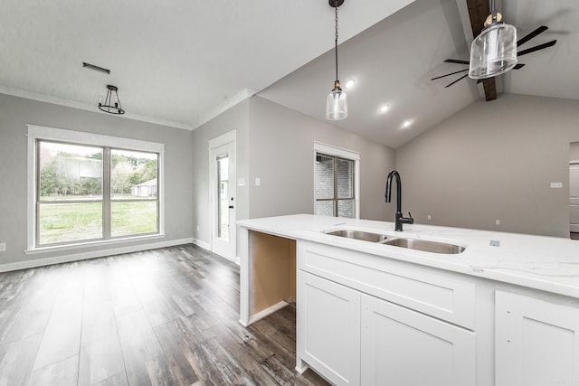 kitchen featuring light stone countertops, sink, white cabinets, vaulted ceiling with beams, and hanging light fixtures