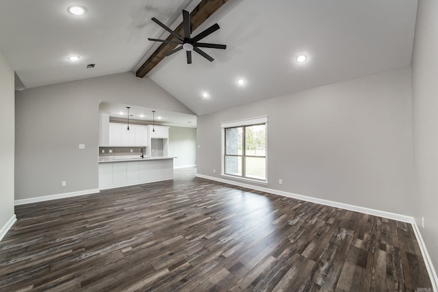 unfurnished living room with ceiling fan, lofted ceiling with beams, and dark wood-type flooring