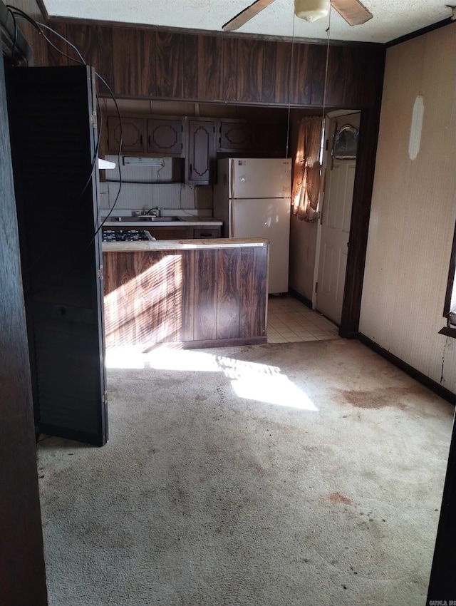 kitchen with ceiling fan, white refrigerator, black fridge, and light carpet