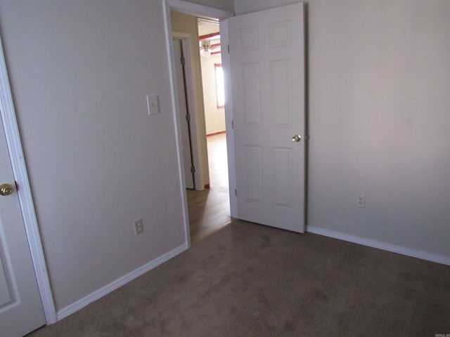 unfurnished bedroom with dark carpet