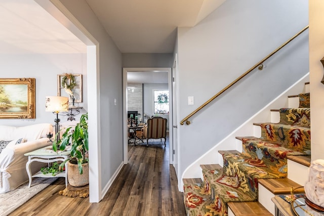 entryway featuring a large fireplace and dark wood-type flooring