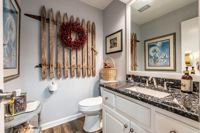 bathroom with hardwood / wood-style floors, vanity, and toilet