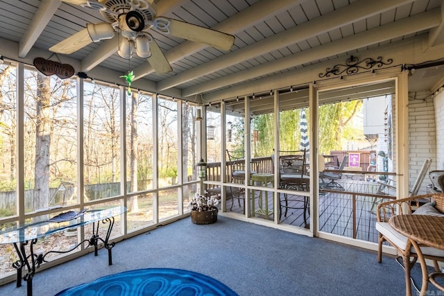 sunroom / solarium featuring beam ceiling and ceiling fan