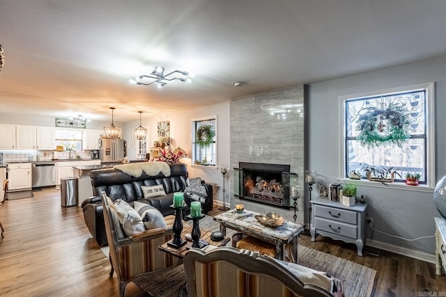 living room featuring a tile fireplace, a wealth of natural light, hardwood / wood-style floors, and sink