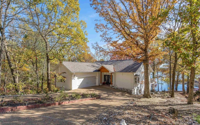 ranch-style home with a garage and a water view