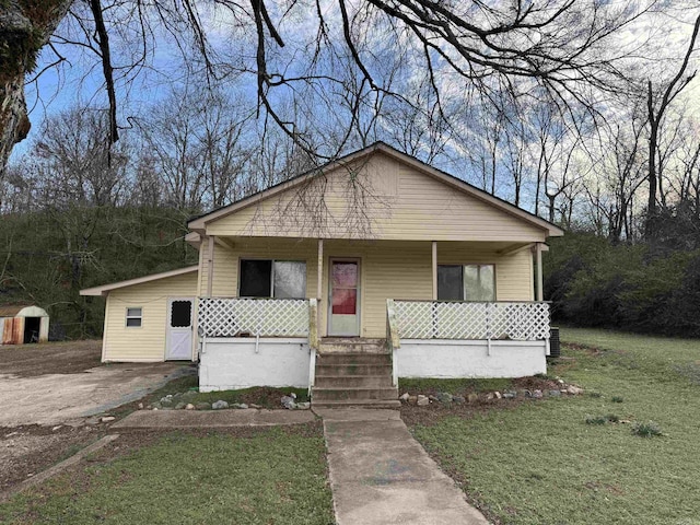 bungalow featuring covered porch and a front lawn