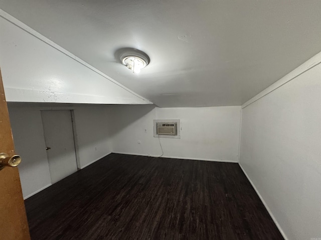 bonus room featuring dark hardwood / wood-style flooring and a wall unit AC